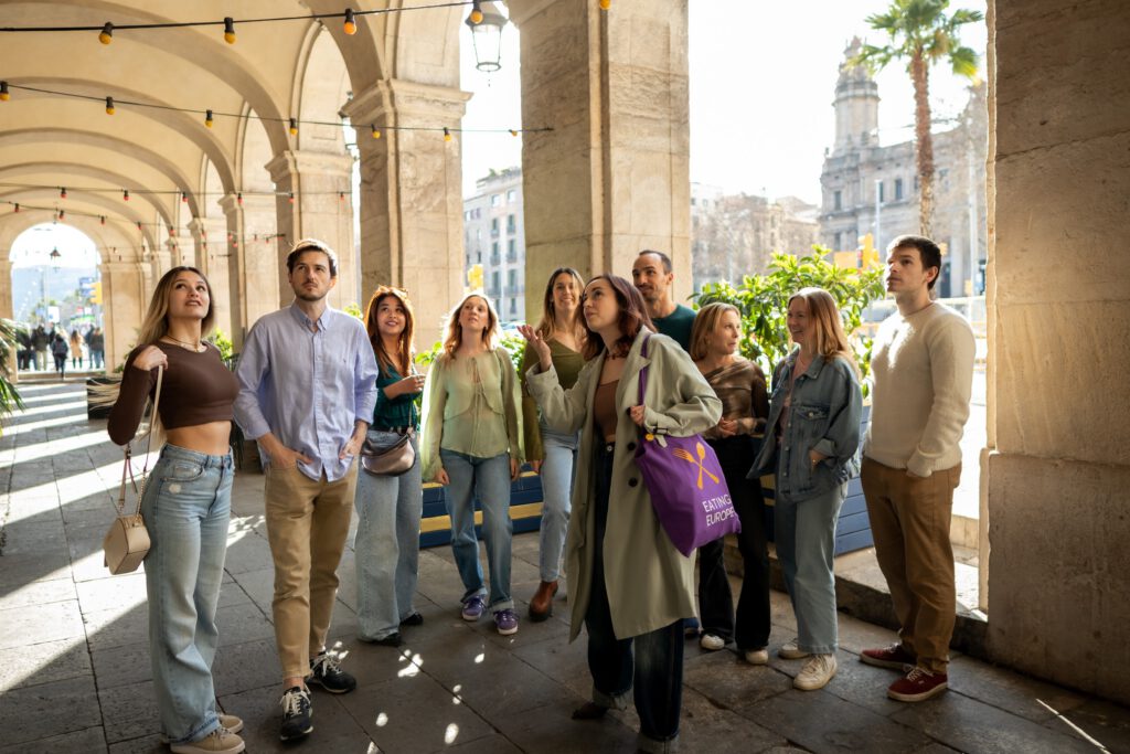 a tour guide pointing out something to her group in barcelona