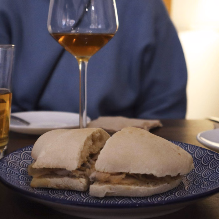 a glass of sherry and a pork sandwich